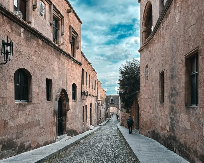 a man walking down a long narrow street