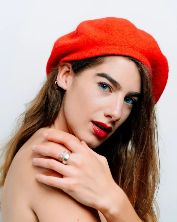 a young woman with long hair wearing a red cap and posing for the camera