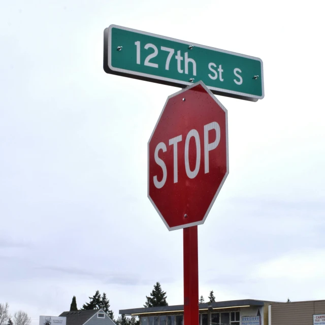 two green and white street signs and a stop sign