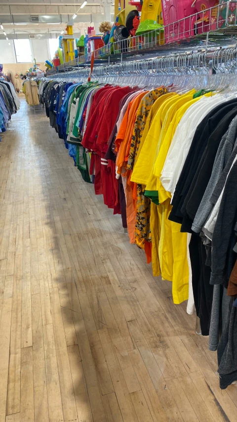 a store that has lots of shirts and tee - shirts hanging up