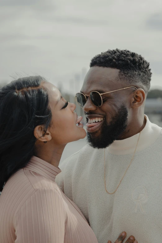 an attractive couple is smiling as they hold their noses close together