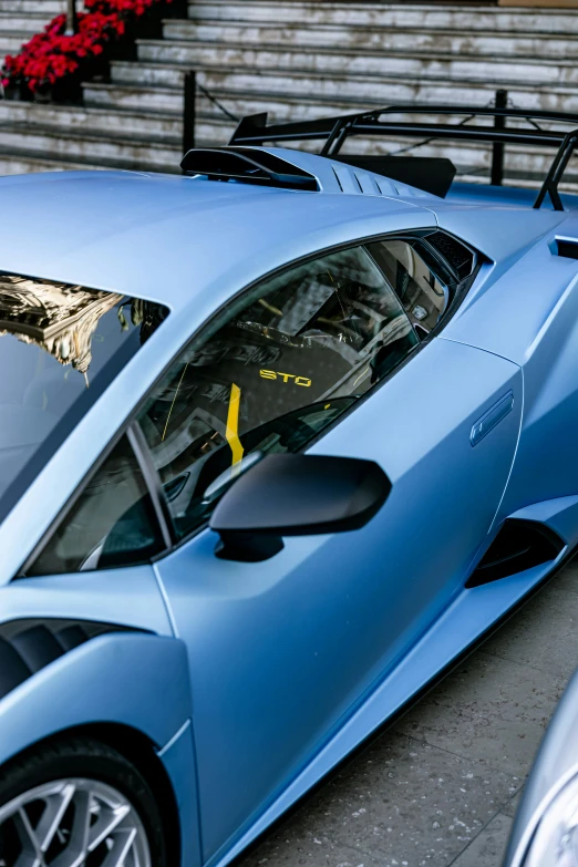 a blue lamb lamb sports car parked in front of some stairs