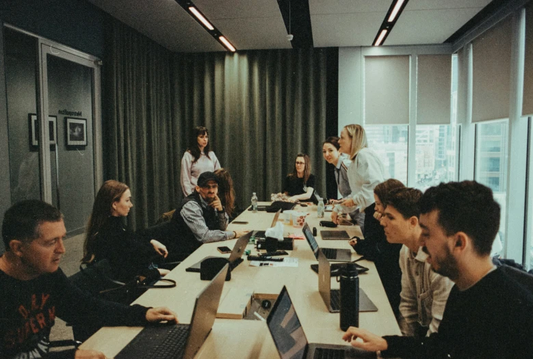 some people are at a long table with computers