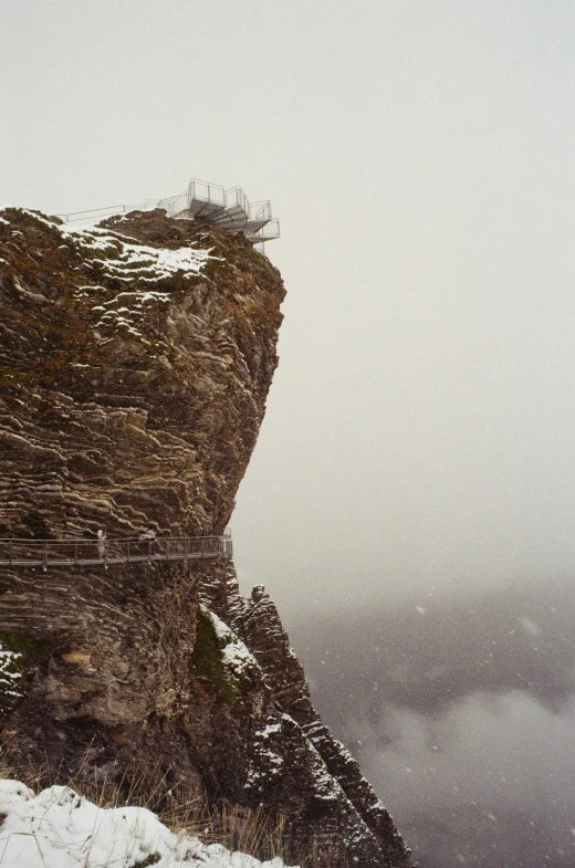 a person walks on a rope going across a cliff