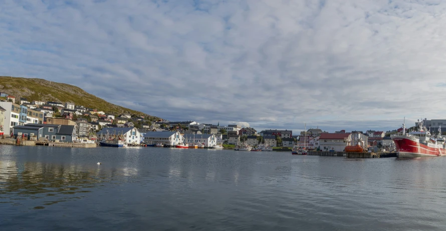 a bay surrounded by tall buildings with small boat tied up to it