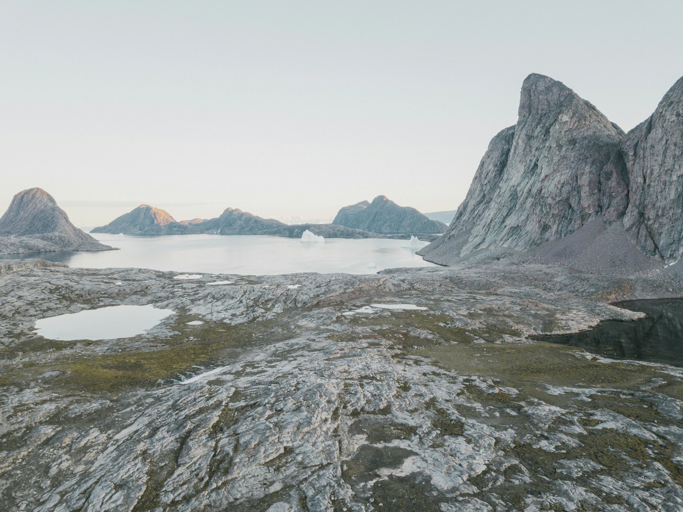 a rocky area with mountains on the side and water in the center