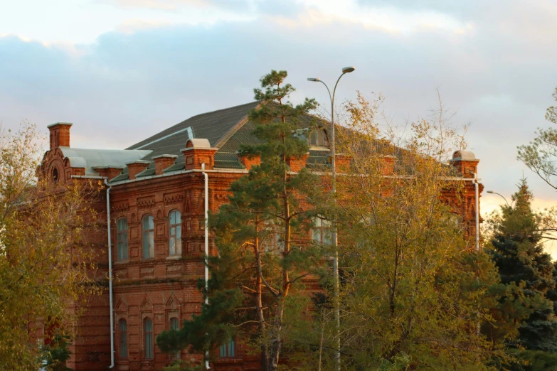 the building next to trees is red and brick