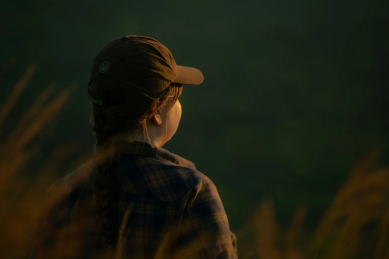 a woman with a baseball cap and ids looking into the distance