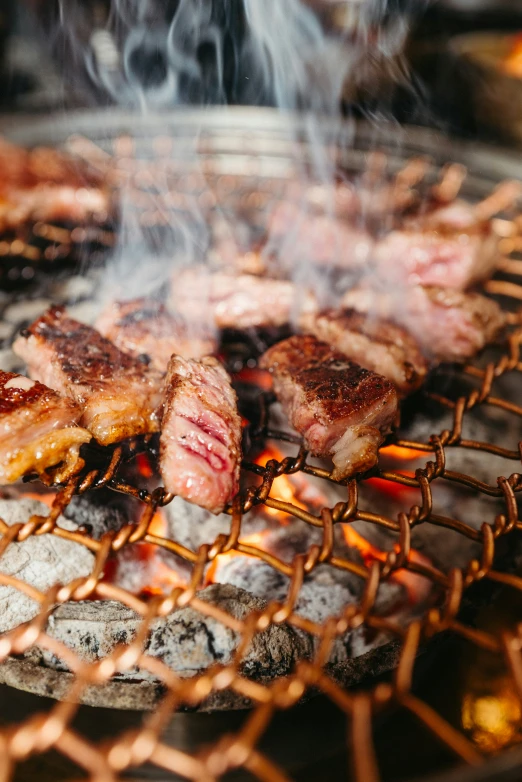 several pieces of meat on the grill with smoke rising from it