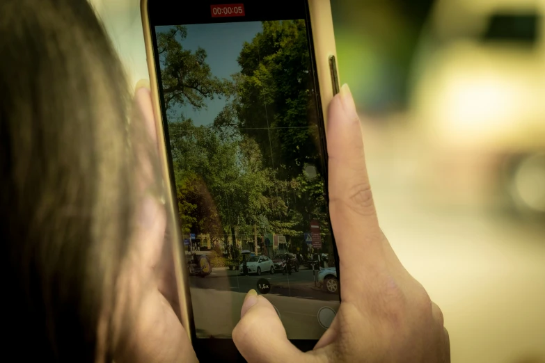 a woman taking a picture of the street on her cell phone