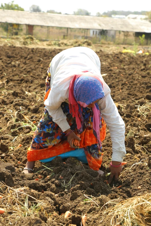 a woman kneeling down in a large field