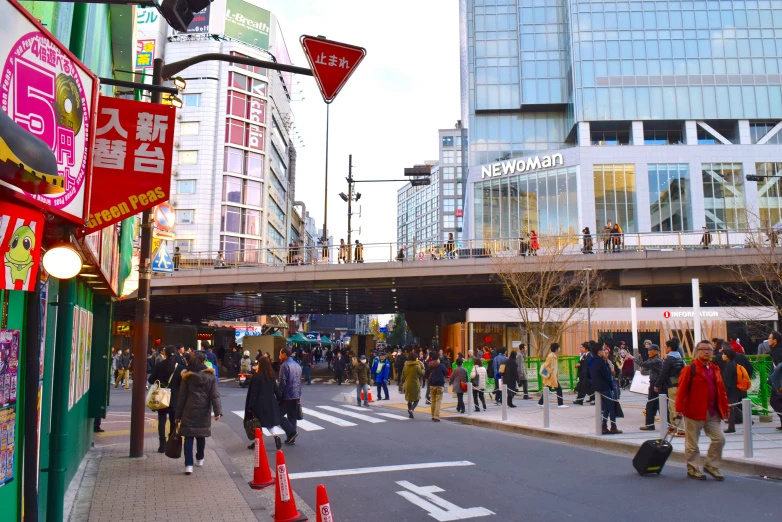 people walking across a street in a crowded city