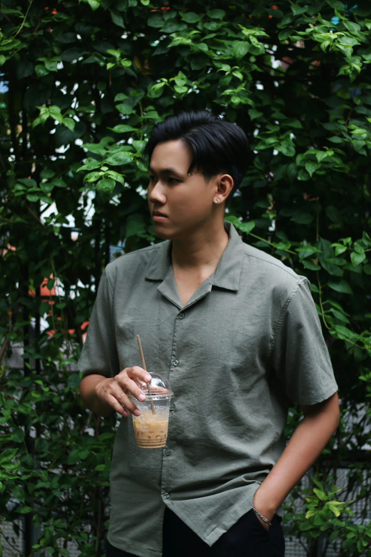 the young man is drinking his coffee and holding a straw