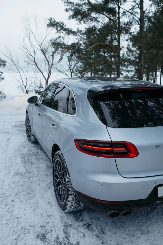 the rear view of a silver car parked on a snowy road