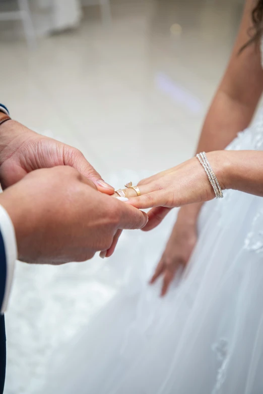 a newly married couple hold hands during their wedding ceremony
