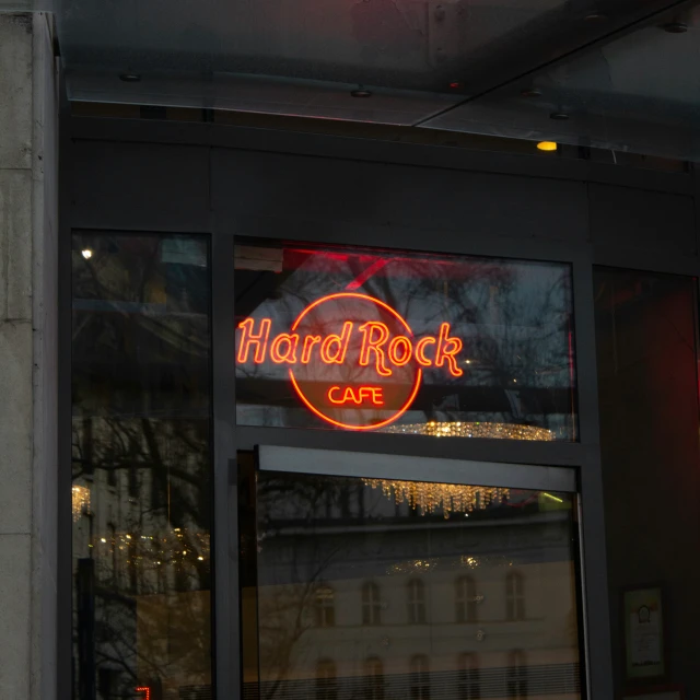 the neon sign is shining brightly in front of the building