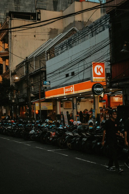 many mopeds parked in front of stores on a street