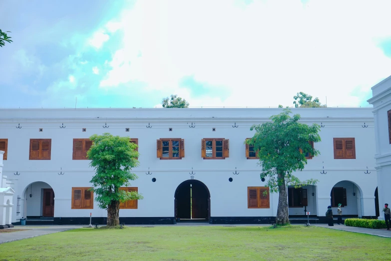 the front of an historic building with trees in the courtyard