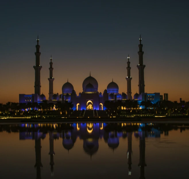 some very large buildings near the water at night