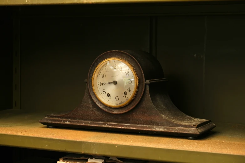 an old clock is sitting on a shelf