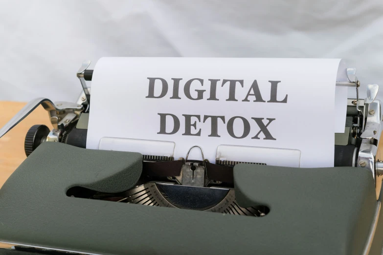 a digital detox text written on a white sheet of paper by a vintage typewriter