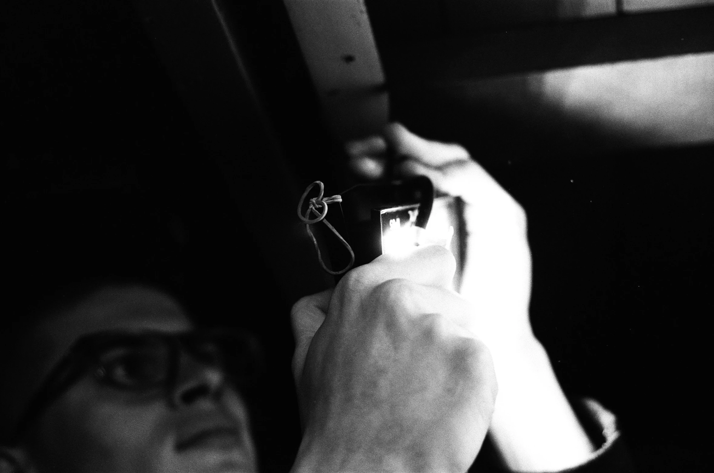 black and white po of a man holding up a cell phone