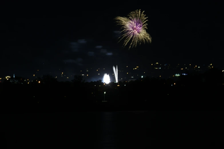 a fireworks is in the night sky over some hills
