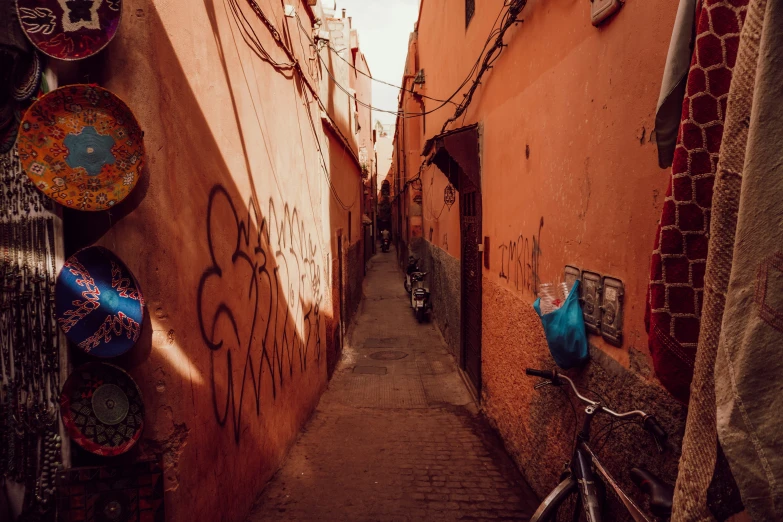 a narrow city street with several signs mounted to the buildings