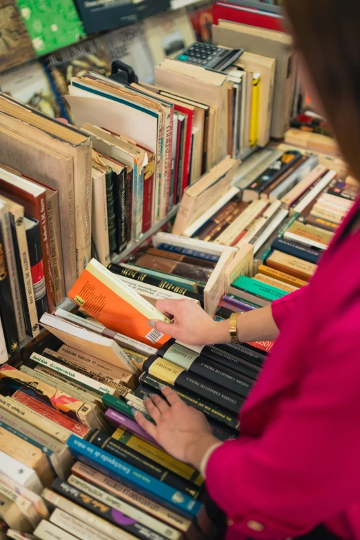 a woman is holding a book by the liry