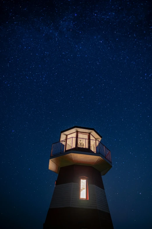 a large lighthouse with an open window at night