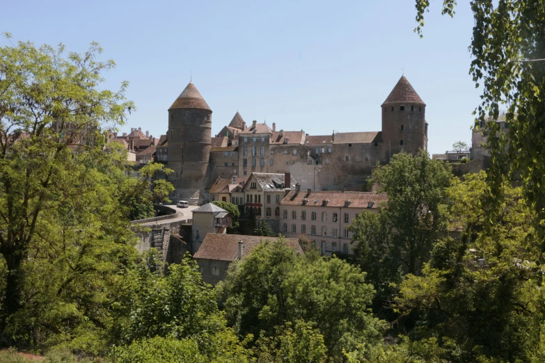 a castle like structure has towers and is surrounded by trees