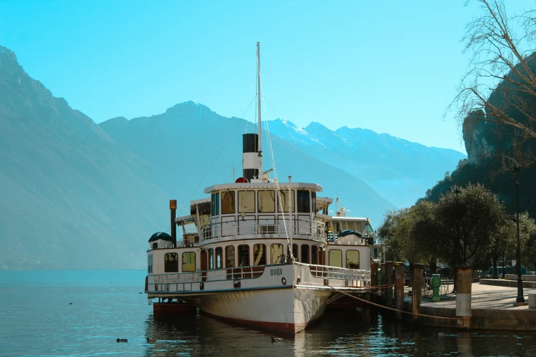 a paddleboat floating in the water in front of mountains