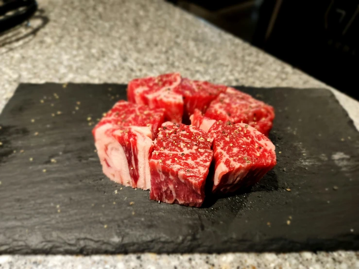 beef chops are sitting on a stone slab