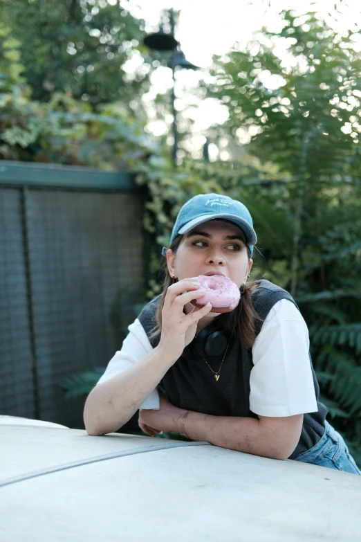 a lady is posing with a donut in her hands