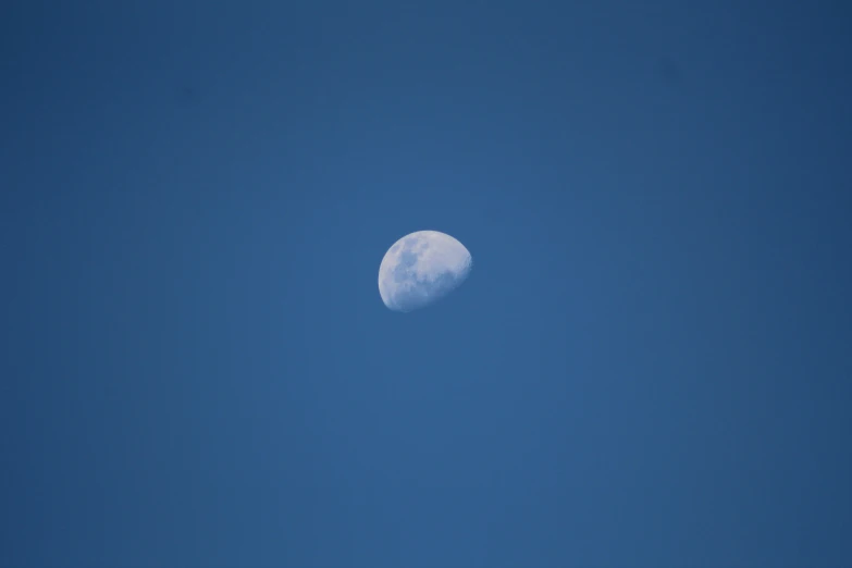 the moon rises in the clear sky with no clouds