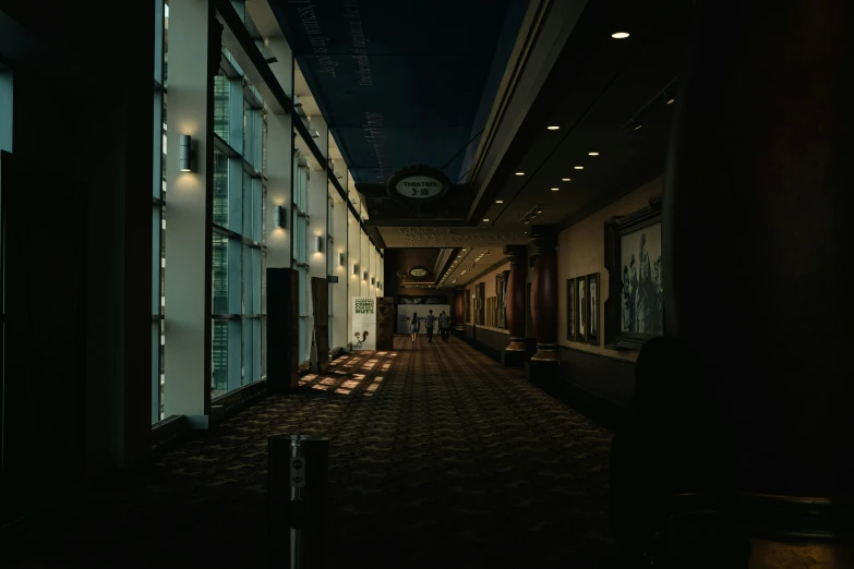 a dark hallway leads into an office building with large windows and a clock