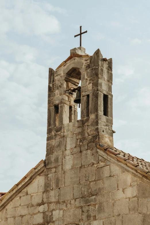 a church tower with a cross and a sky in the background