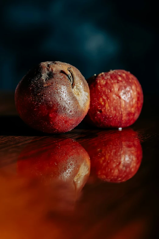 two apples sitting next to each other on a table