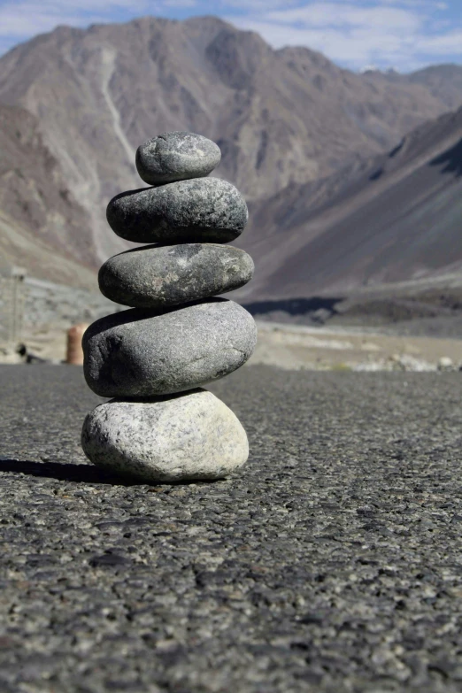 a stack of rocks in front of some mountains