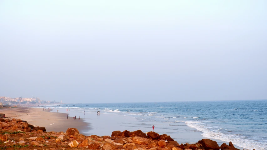 a beach with many people on it and two surfers