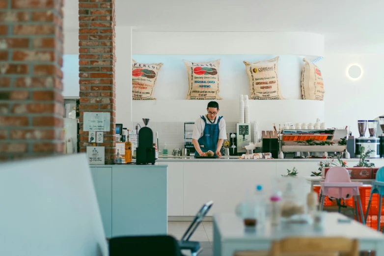 a man standing in front of a counter with various items behind him