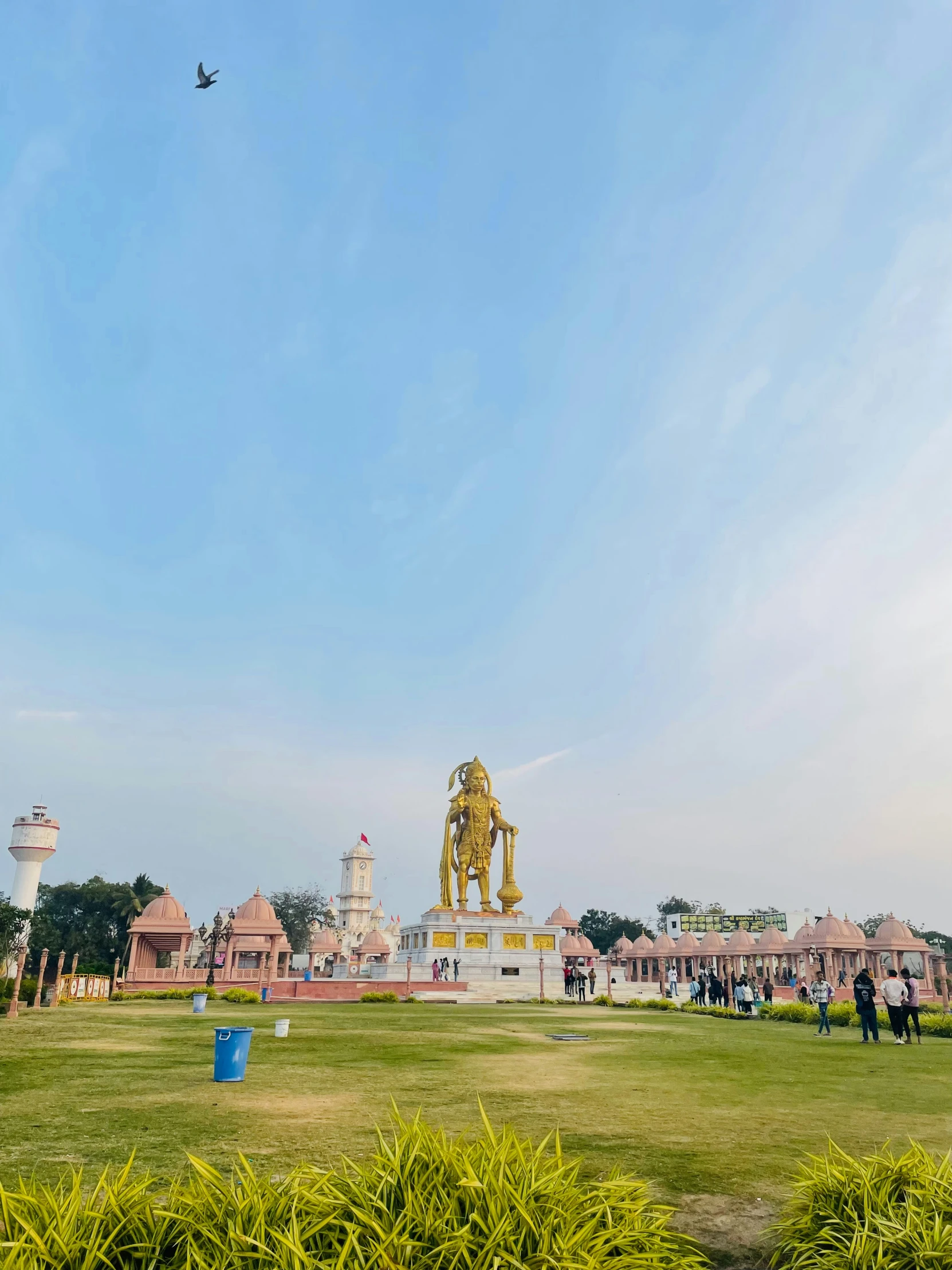 a park with people playing a game and two flying kites