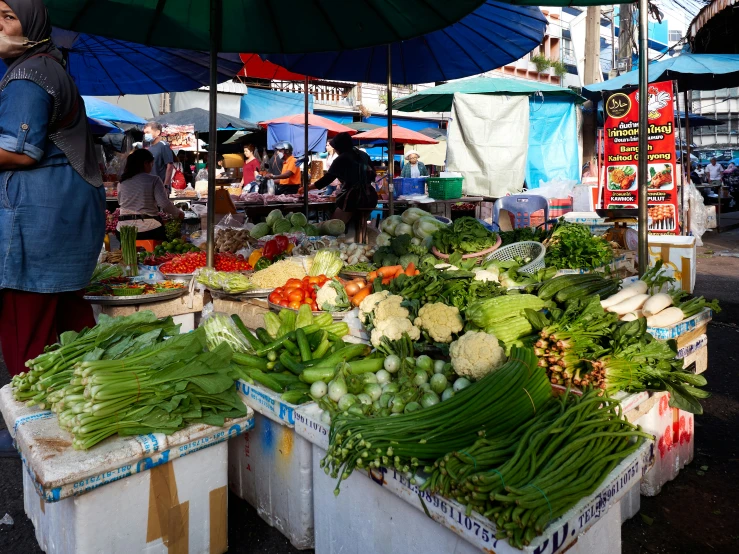 a man standing in a market holding an umbrella