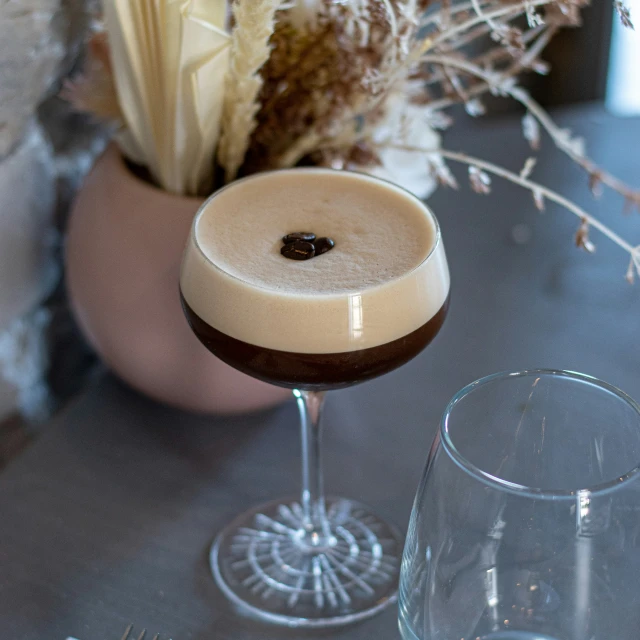 an alcohol and dessert drink, accompanied by a vase of plants