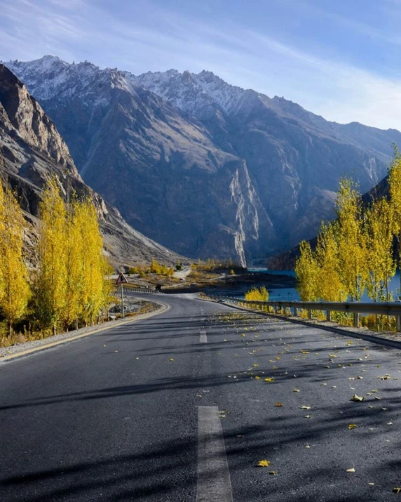 a mountain range with trees changing color in the fall