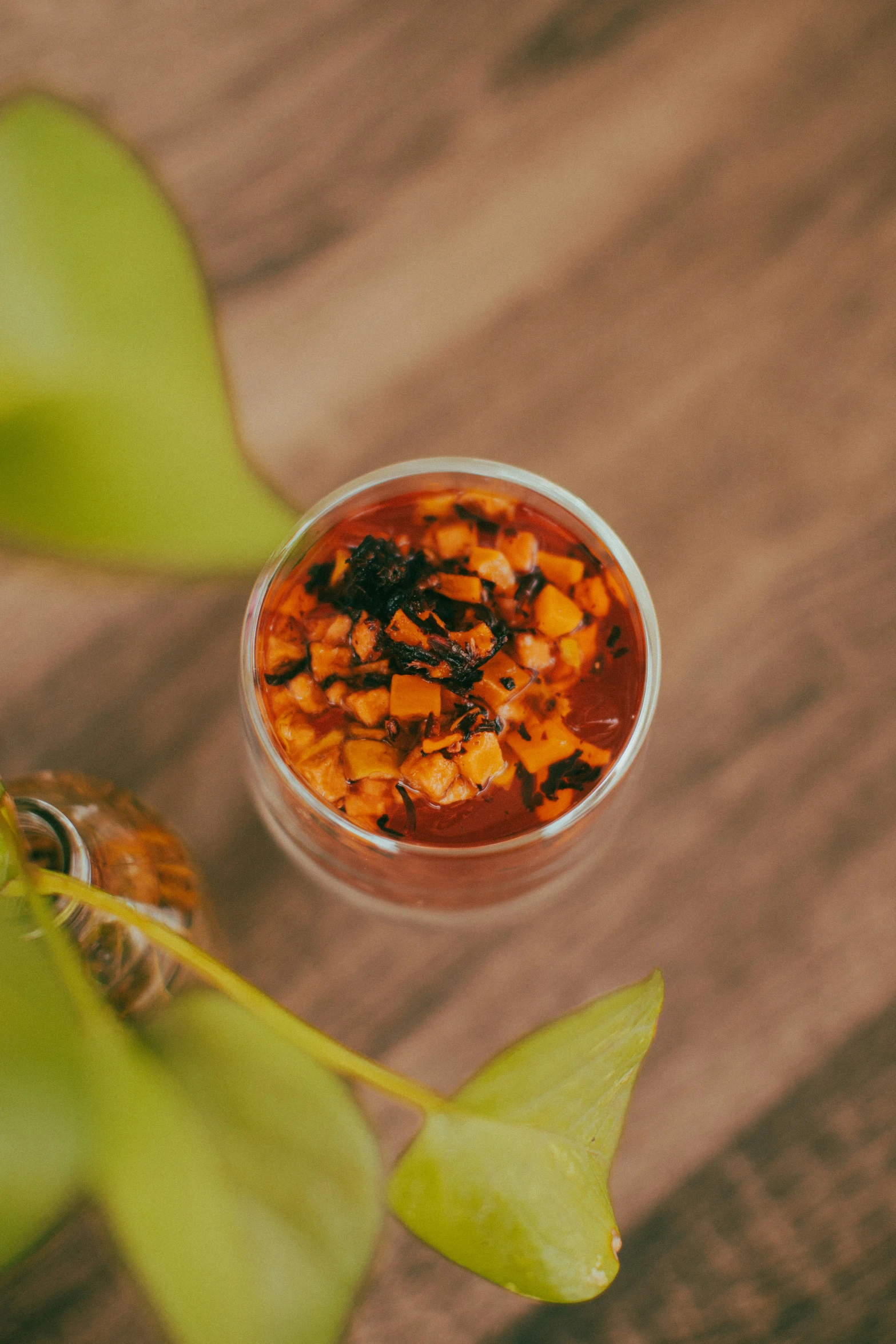 a bowl filled with vegetables sitting on a table next to leaves