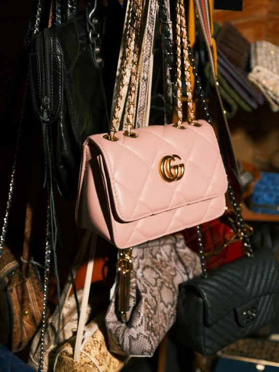 a variety of purses are piled high on display