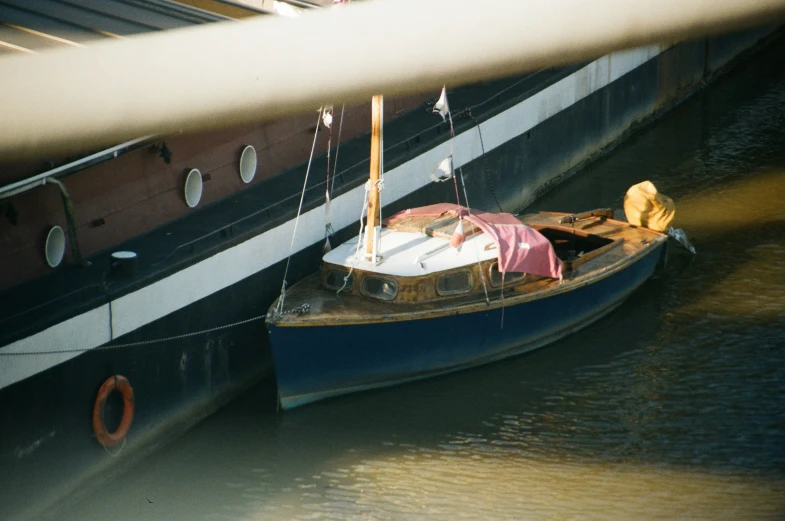 small sailboat docked next to a large boat