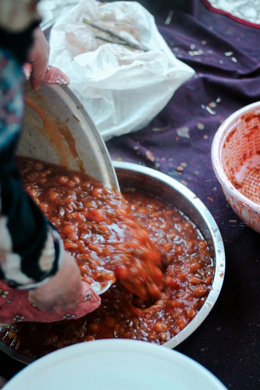 a person scooping some beans into a bowl