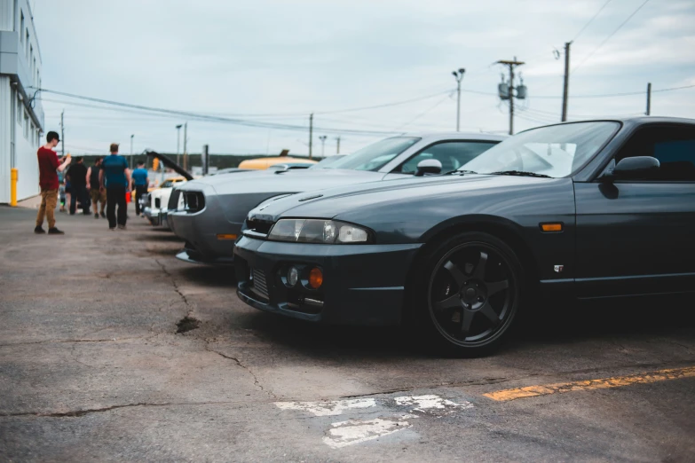 two blue bmw cars and a man waiting in line